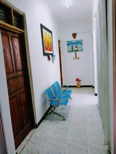 a hallway with a blue chair in a room at bed and breakfast in Kidoti