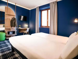 a hotel room with a large bed and a desk at Ibis Styles Colmar Centre in Colmar +65 photos