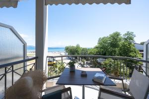 ein Balkon mit Tisch und Blick auf den Strand in der Unterkunft The Ark in Stavros
