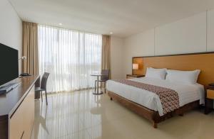 a hotel room with a bed and a large window at Estelar Alto Prado in Barranquilla