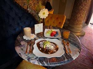 a table with a dessert and a plate of fruit on it at La Senoría Hotel in San Miguel de Allende