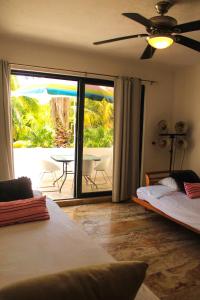 a bedroom with two beds and a patio with a table at Suites Marea in Cancún +56 photos