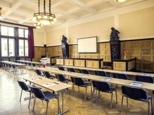 a large room with tables and chairs and a whiteboard at Mercure Ostrava Center in Ostrava