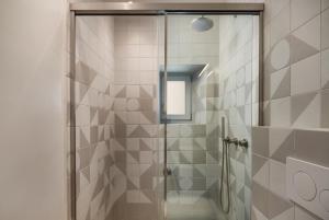 a shower with a glass door in a bathroom at Serene Shore Serifos in Alona +24 photos