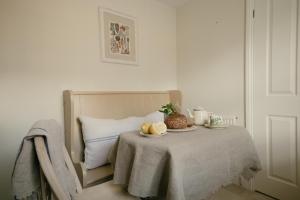 a bed with a table with two plates of food on it at Central Village Cottage, The Corders in Moreton in Marsh