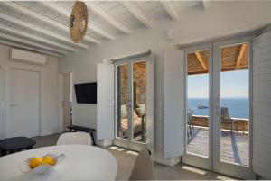 a room with a table and a view of the ocean at Serene Shore Serifos in Alona