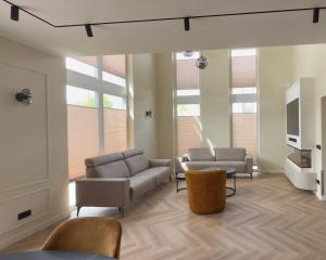 a living room with two couches and a tv at Villa Aurelia Spa, Zeewolde 52 in Zeewolde