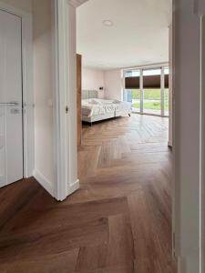 a bedroom with a bed and a wooden floor at Villa Aurelia Spa, Zeewolde 51 in Zeewolde +62 photos