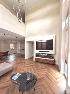 a living room with a large flat screen tv at Villa Aurelia Spa, Zeewolde 51 in Zeewolde