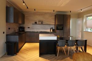 a kitchen with a black island in a room at Villa Aurelia Spa, Zeewolde 52 in Zeewolde