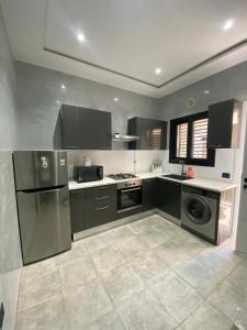 a kitchen with black and silver appliances in a room at Résidence Mariem Tantana in Akouda