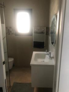 a bathroom with a sink and a toilet and a window at Résidence Mariem Tantana in Akouda