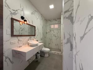 a bathroom with a sink and a toilet at Hotel La Mar Playas in Playas +104 photos