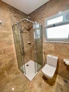 a bathroom with a shower and a toilet at Grand Stylish Two bedrooms Apartment in El Alamein