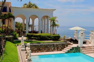 a house with a swimming pool in front of the ocean at Verdaad Mansion in La Libertad