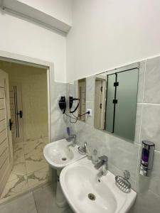 a bathroom with two sinks and a large mirror at Pure Hostel in Tashkent