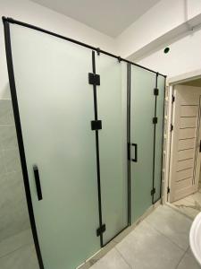 a large glass shower door in a bathroom with a dooricipated at Pure Hostel in Tashkent