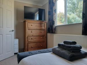 a bedroom with a bed and a dresser with a tv at Marley Farm Bungalow in Deal +74 photos
