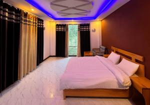 a bedroom with a large bed with a purple lighting at Comfort Inn in Kalām