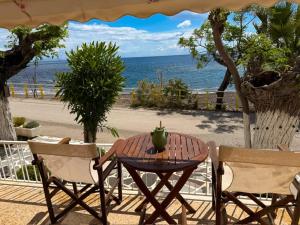 a table with an apple on it sitting between two chairs at Vasiliki Palli Rooms in Methana