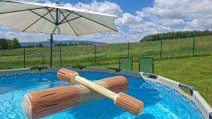 an umbrella and a chair in a swimming pool at Idzikowianka in Idzików