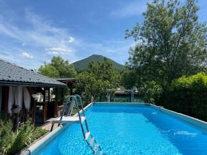 a swimming pool with a slide in front of a house at AM Una Lux House in Bihać
