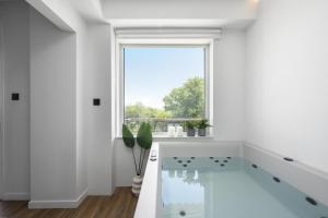 ein weißes Badezimmer mit großem Fenster und Badewanne in der Unterkunft The Ark in Stavros
