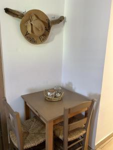 a table with two chairs and a hat on the wall at Vasiliki Palli Rooms in Methana +37 photos