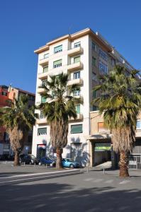 a group of palm trees in front of a building at Nonna Rina b&b in Savona