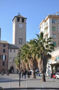 a clock tower with palm trees in front of a building at Nonna Rina b&b in Savona