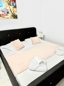 a large bed with white sheets and pillows on it at Serene Studios in Eforie Nord