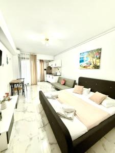 a bedroom with two beds and a living room at Serene Studios in Eforie Nord