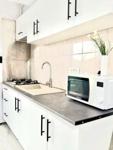 a white kitchen with a microwave and a sink at Serene Studios in Eforie Nord +160 photos