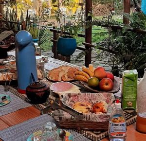 a picnic table with a basket of fruit and bread at Chalés Recanto da Aldeia in Itanhaém