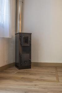 a metal stove in a room with a wooden floor at Casa con parra de uva y paz in Grou