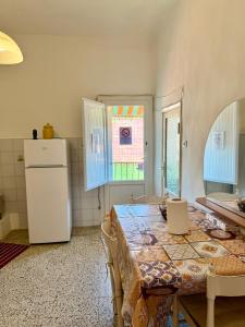 a kitchen with a table and a refrigerator at Ostello moderno centro- cucina Wi-Fi in Livorno