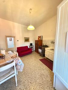 a living room with a red couch and a kitchen at Ostello moderno centro- cucina Wi-Fi in Livorno