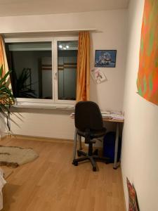 a room with a desk and a chair next to a window at Winterthur in Winterthur +1 photo