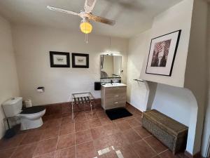 a bathroom with a toilet and a ceiling fan at Casa La Nuez in Almedinilla +69 photos