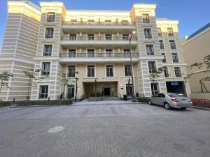 a large building with a car parked in front of it at Grand Stylish Two bedrooms Apartment in El Alamein