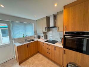 a kitchen with wooden cabinets and a black appliance at Fatjon Propeties in Drayton +5 photos