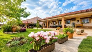 a house with a garden with flowers in the yard at La Casona del Bullaque in El Robledo