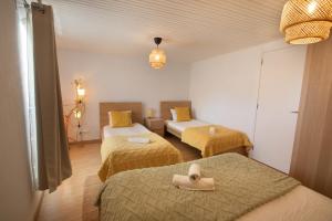 a room with two beds with a hat on them at Casa con parra de uva y paz in Grou