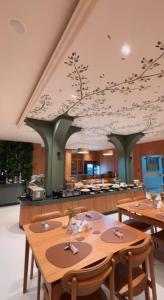 a dining room with tables and a kitchen at Agulhon Hotel in Primavera do Leste