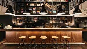 a bar with stools in front of a counter at Ruby Sofie Hotel Vienna by IHG in Vienna
