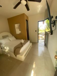 a bedroom with a bed with a ceiling fan at Sélanna in El Paredón Buena Vista +35 photos
