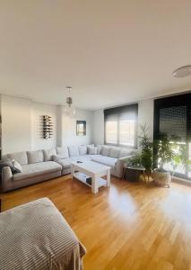 a living room with a couch and a table at Ático La Puerta de Logroño, con terraza y piscina! in Logroño