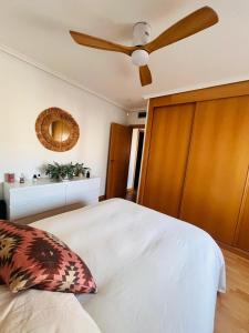 a bedroom with a bed with a ceiling fan at Ático La Puerta de Logroño, con terraza y piscina! in Logroño