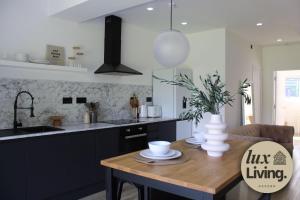a kitchen with a wooden table and a sink at Lux Living No 6 Luxury 1-Bed Free Parking Oxford in Oxford