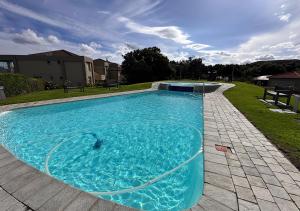 a large blue swimming pool in a yard at The Fairway Apartment in Plettenberg Bay